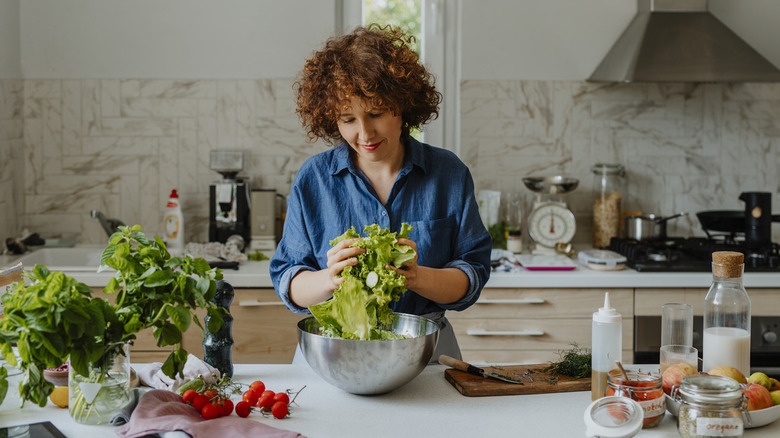 woman tossing a salad in kitchen