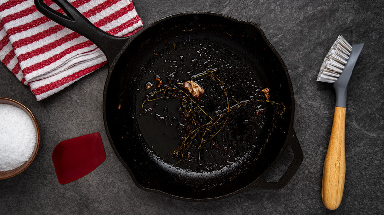 Cast-iron pan with used garlic and herbs