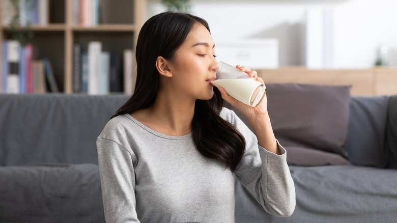 Person drinking glass of buttermilk