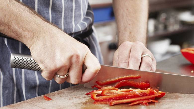 Man slicing red bell peppers