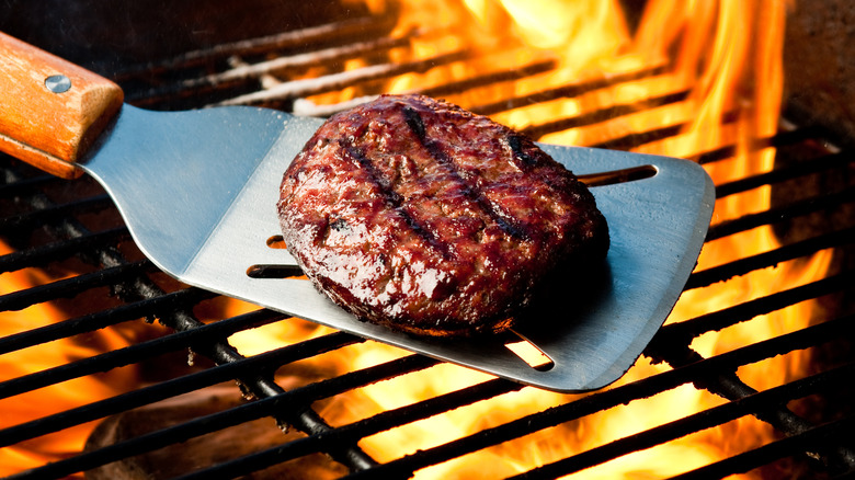 Burger on spatula over grill