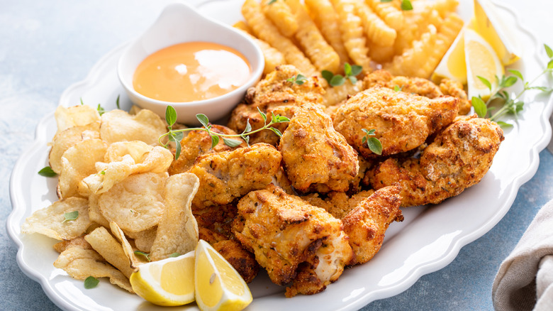 Catfish nuggets, fries, potato chips, and sauce