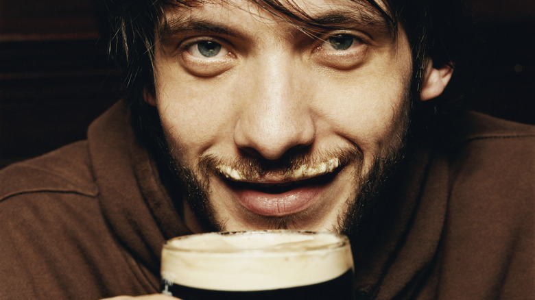 Man drinking bear with foam in mustache