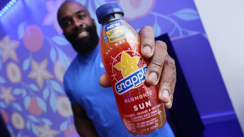 Man holding a bottle of Snapple Elements Sun