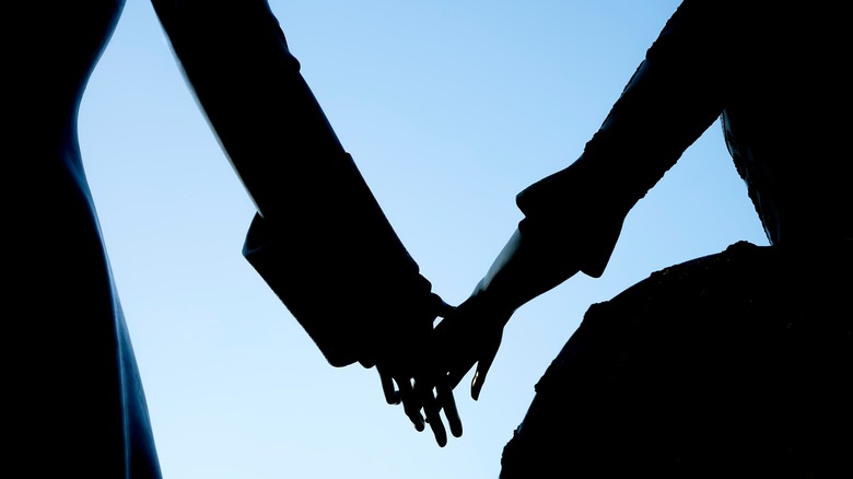 Couple's silhouette touching hands