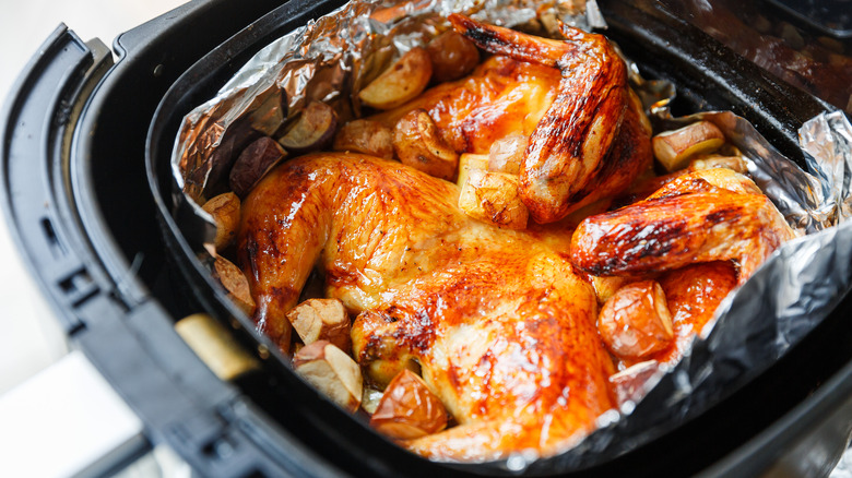 Chicken parts packed into a foil lined air fryer