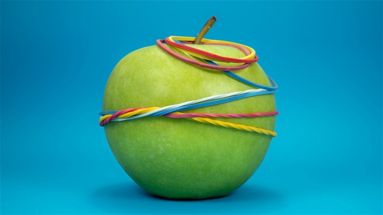 Green apple wrapped in rubber bands