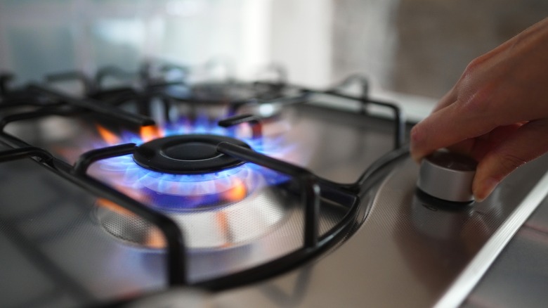 Person lighting gas stove burner