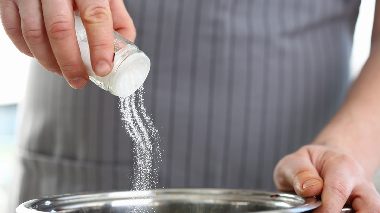 Sprinkling salt into steaming pot