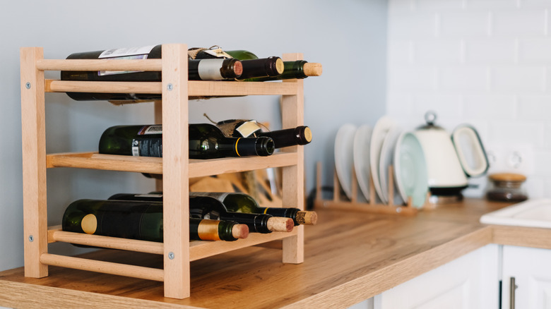 Wine bottles on a small rack on a kitchen counter