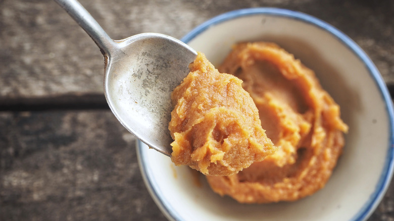 Miso paste on spoon above bowl