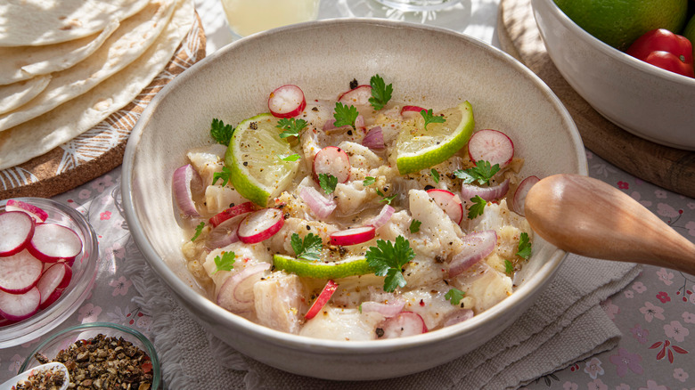 bowl of ceviche marinating with limes