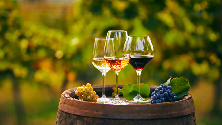 Three glasses of wine on a wooden barrel