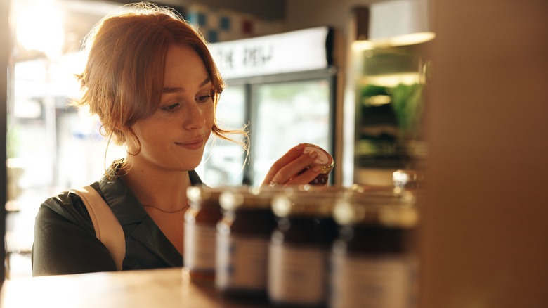 woman reading labels on jars