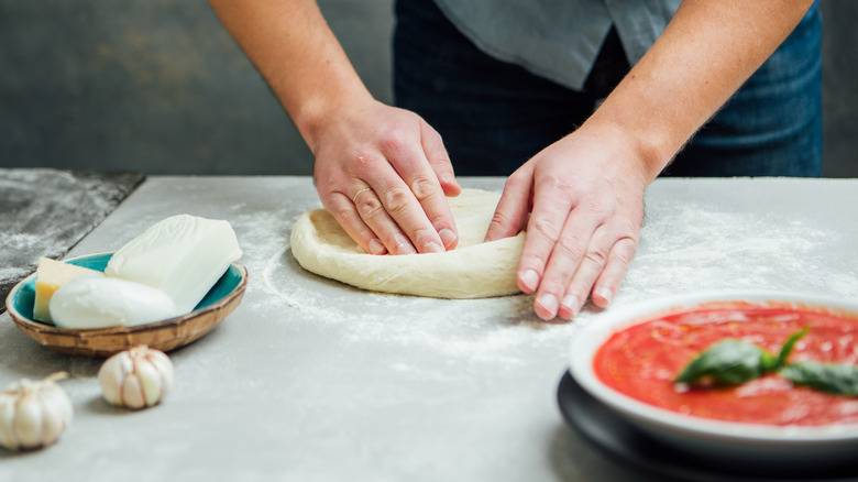 Person kneading pizza dough