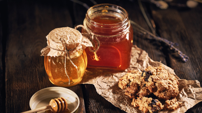 Pots of honey with cookies