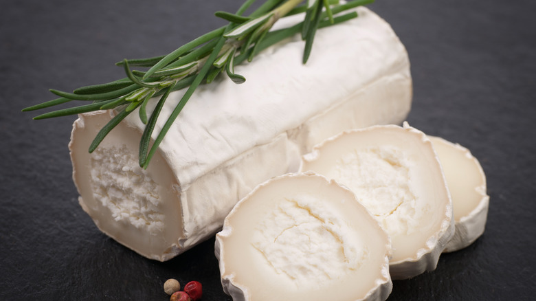 A log of fresh goat cheese with rosemary sprig