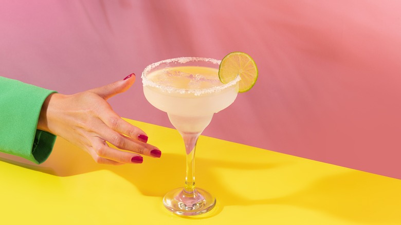 Woman's hand reaching for a margarita 