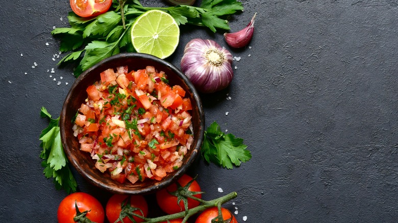 Chunky salsa with fresh ingredients surrounding it