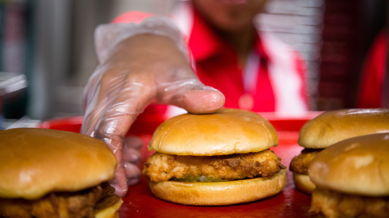 placing chicken sandwiches on tray