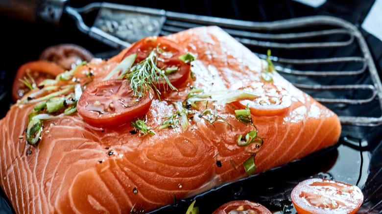 Salmon fillet in pan with herbs