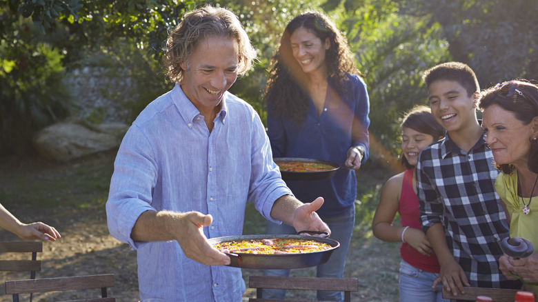 Family preparing to enjoy paella