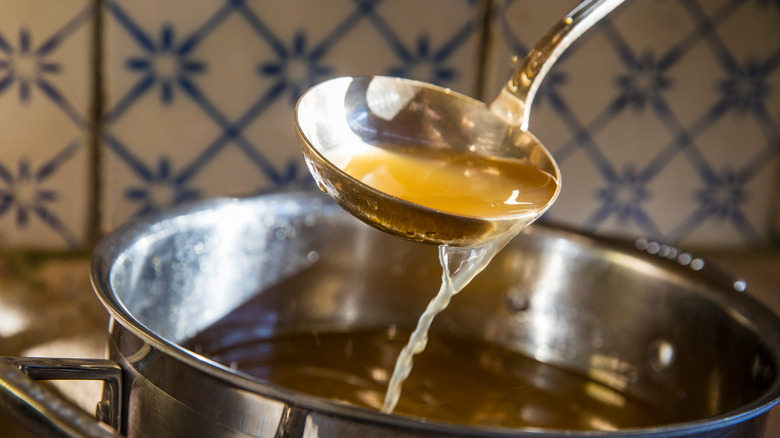 Ladling broth from a pot