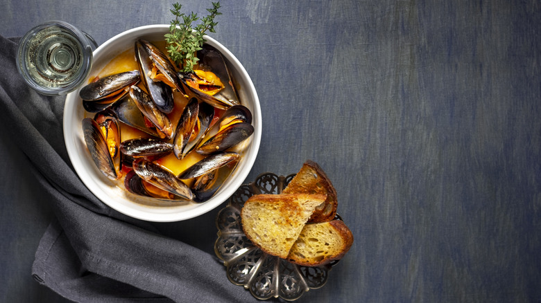 Mussels in a bowl next to bread