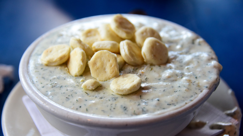 A bowl of clam chowder with oyster crackers