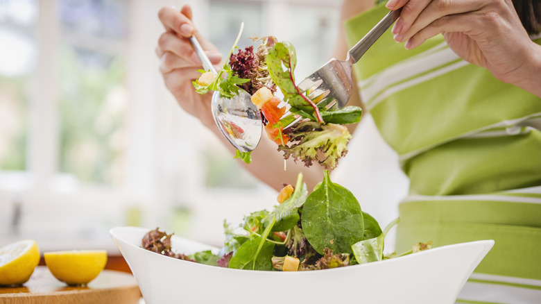 hands tossing salad