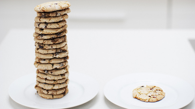 stack of chocolate chip cookies next to single cookie