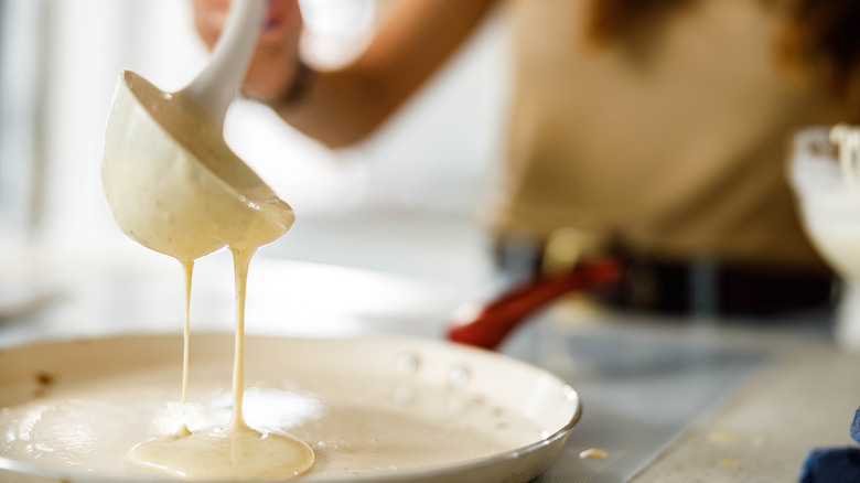 Person pouring batter onto pan 