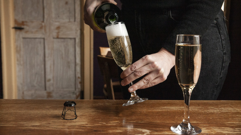 Person pouring Champagne into flutes