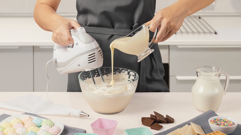 pouring batter into bowl with hand mixer