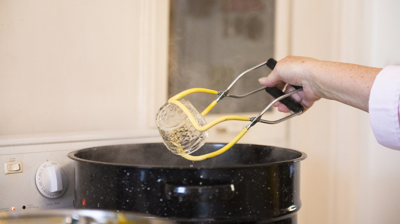 lifting a jar with canning tongs