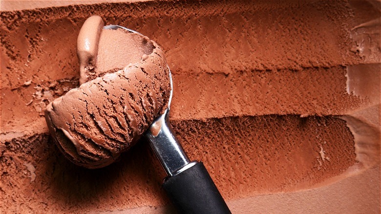 Metal utensil scooping chocolate ice cream