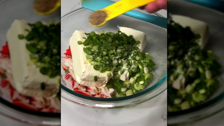 scallions and cream cheese in a glass bowl for crab rangoons