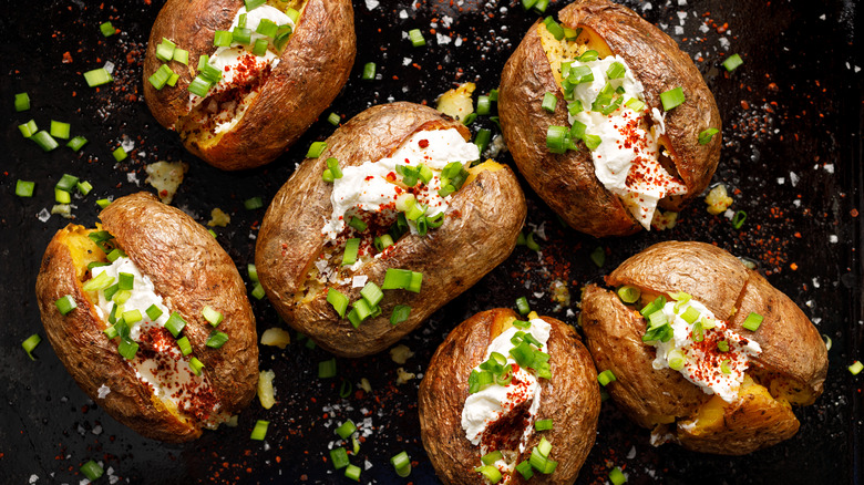 baked potatoes topped with sour cream and seasoning