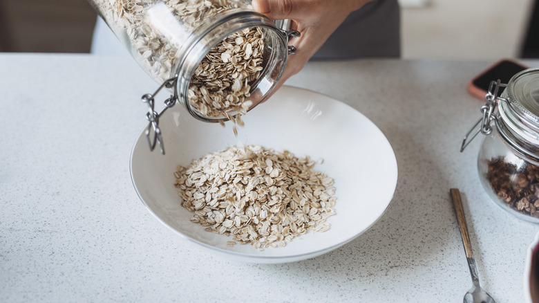 pouring dry oatmeal into bowl