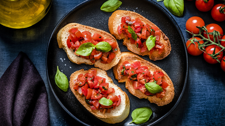 Tomato bruschetta on black plate