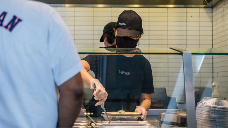 Chipotle employee prepares food 