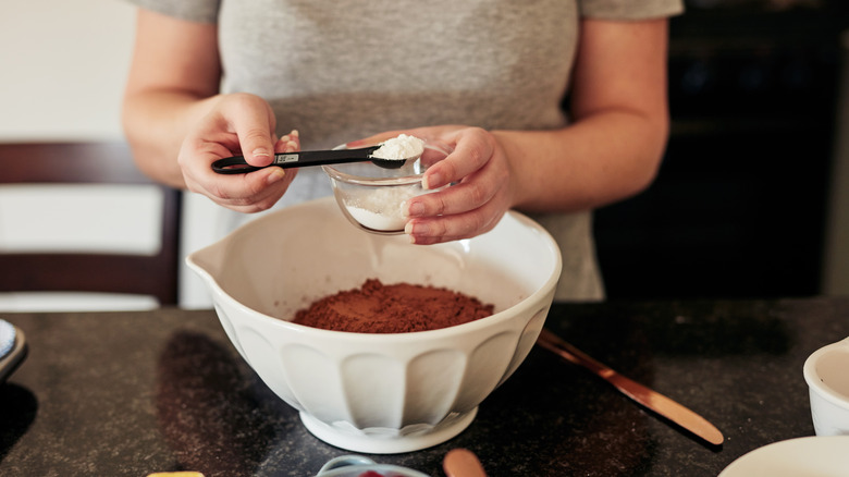 Hand measuring baking soda