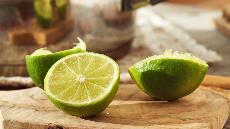 Halved limes on cutting board in kitchen.