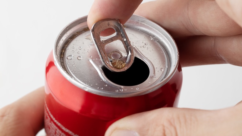 finger under soda can tab