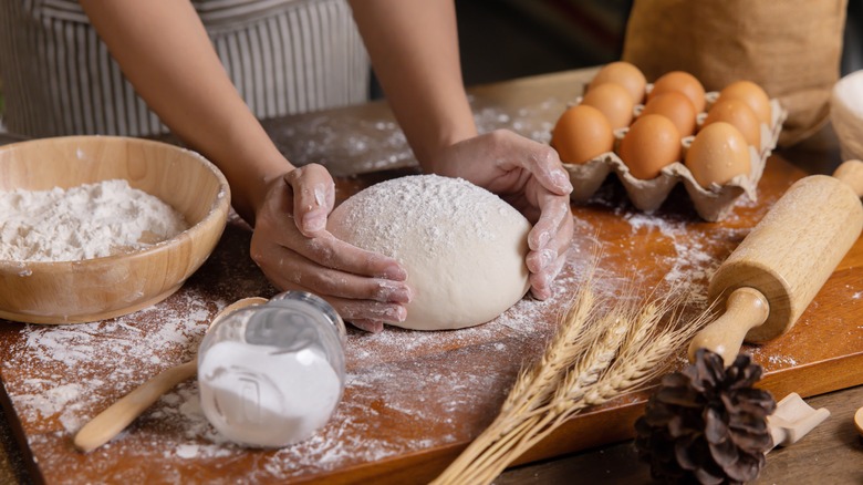 Person shaping dough on board