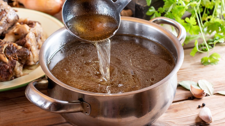 pot of beef broth with ladle