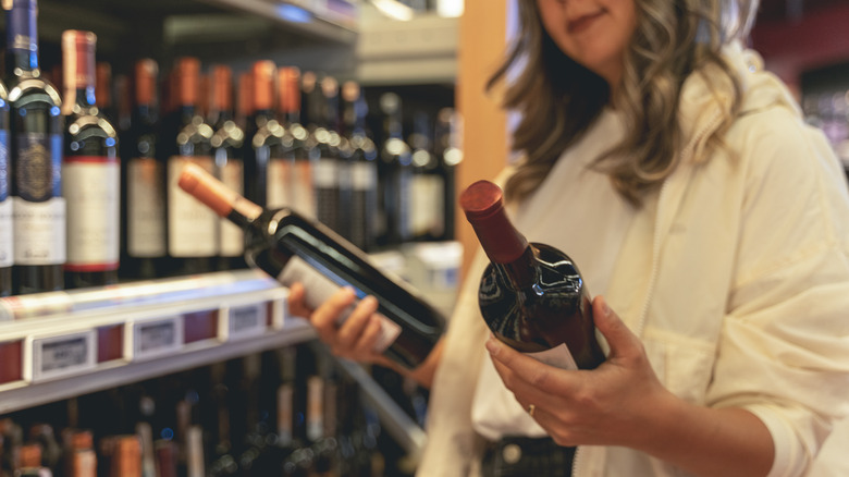 A woman choosing bottles of wine