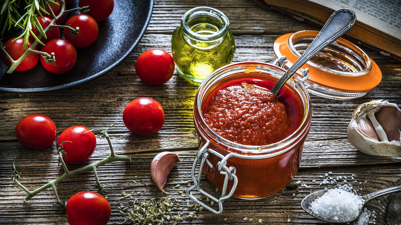 jar of tomato paste with spoon in it