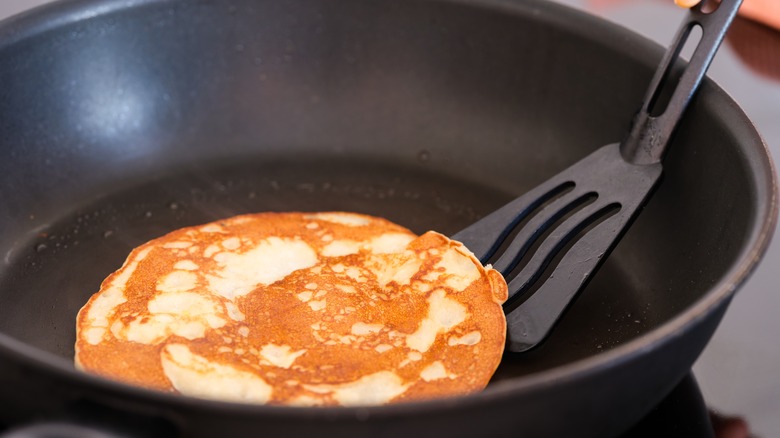 Pancake being flipped in a pan