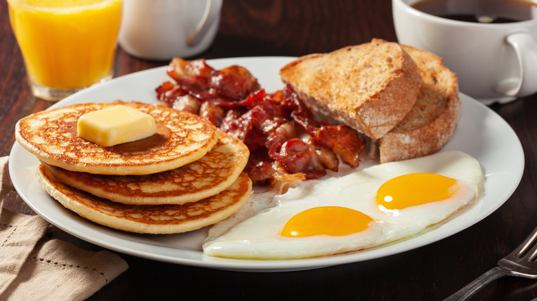 Pancake breakfast with bacon, toast, and eggs